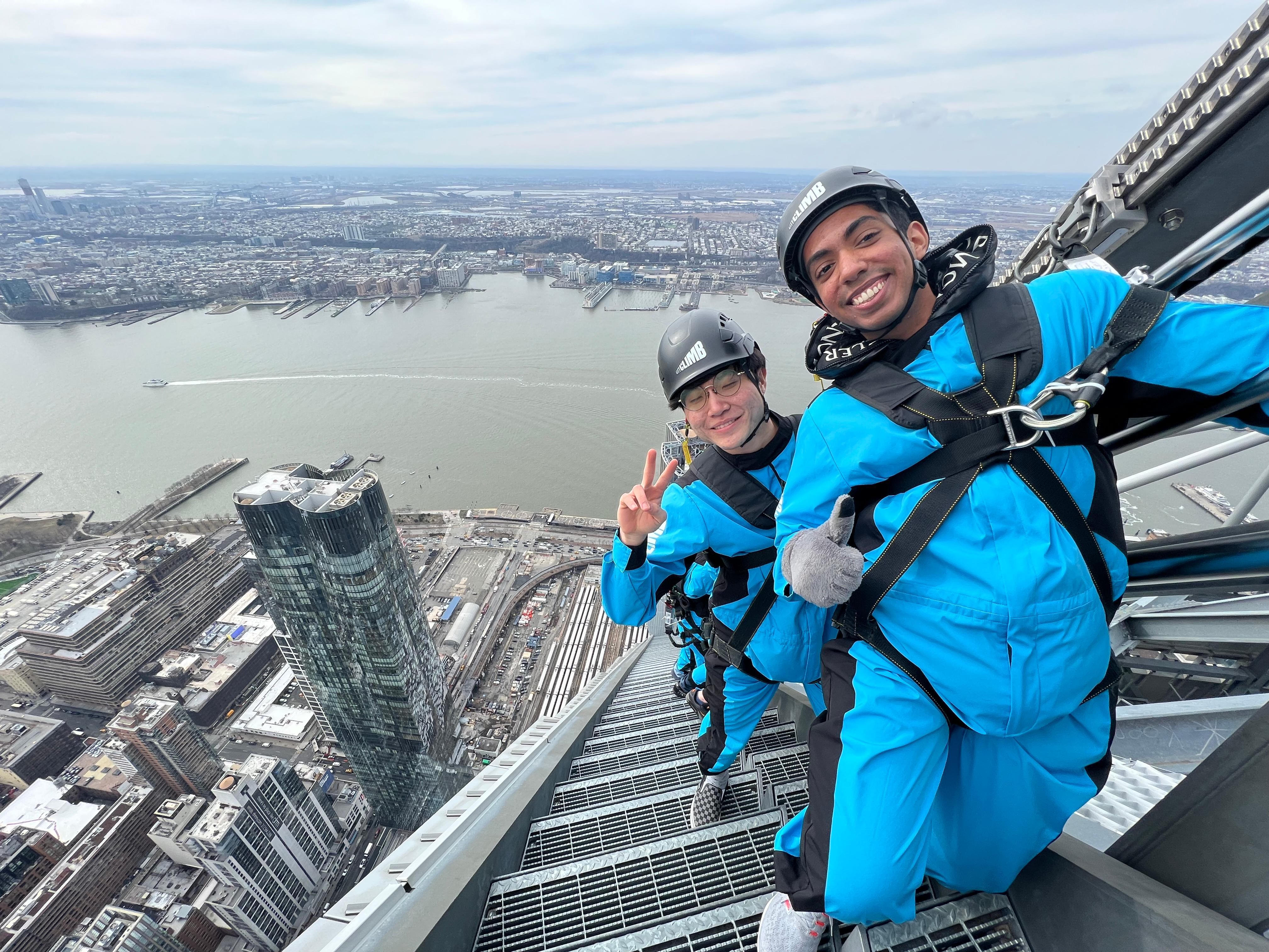 Hadong climbing with safety gear over a city skyline.
